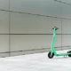 A green complete scooter parked at the corner of the street