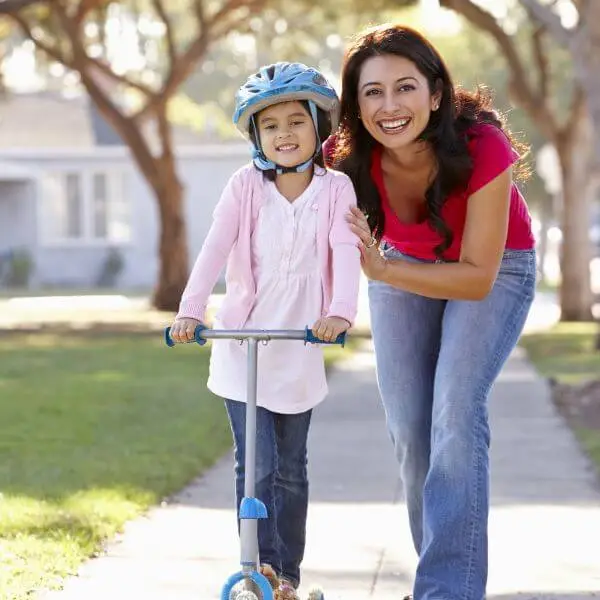 mother setting achievable goals while teaching her daughter to learn to scooter