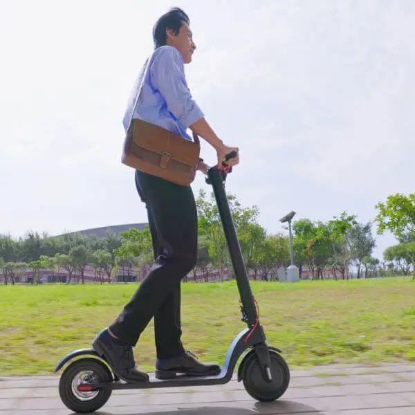 A man riding on an electric scooter in a park