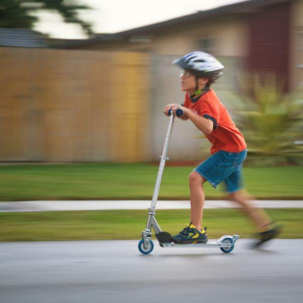 Kids on scooter wearing helmet