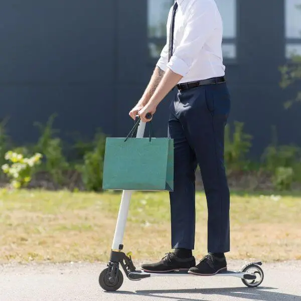 A man on electric scooter with shopping bag