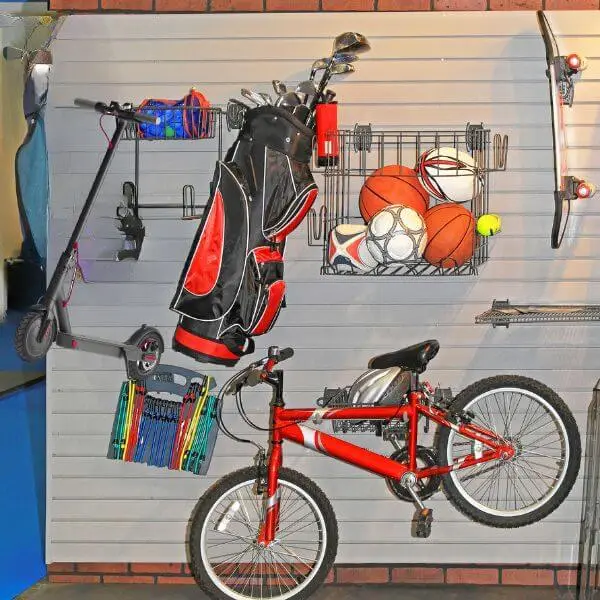 Wall hanging scooter storage racks holding scooter, bicycle, golf kit and footballs